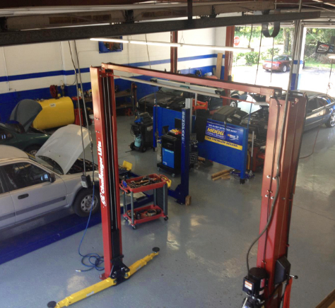 Inside Auto Point Car Care's service garage in Apopka with vehicles on lifts