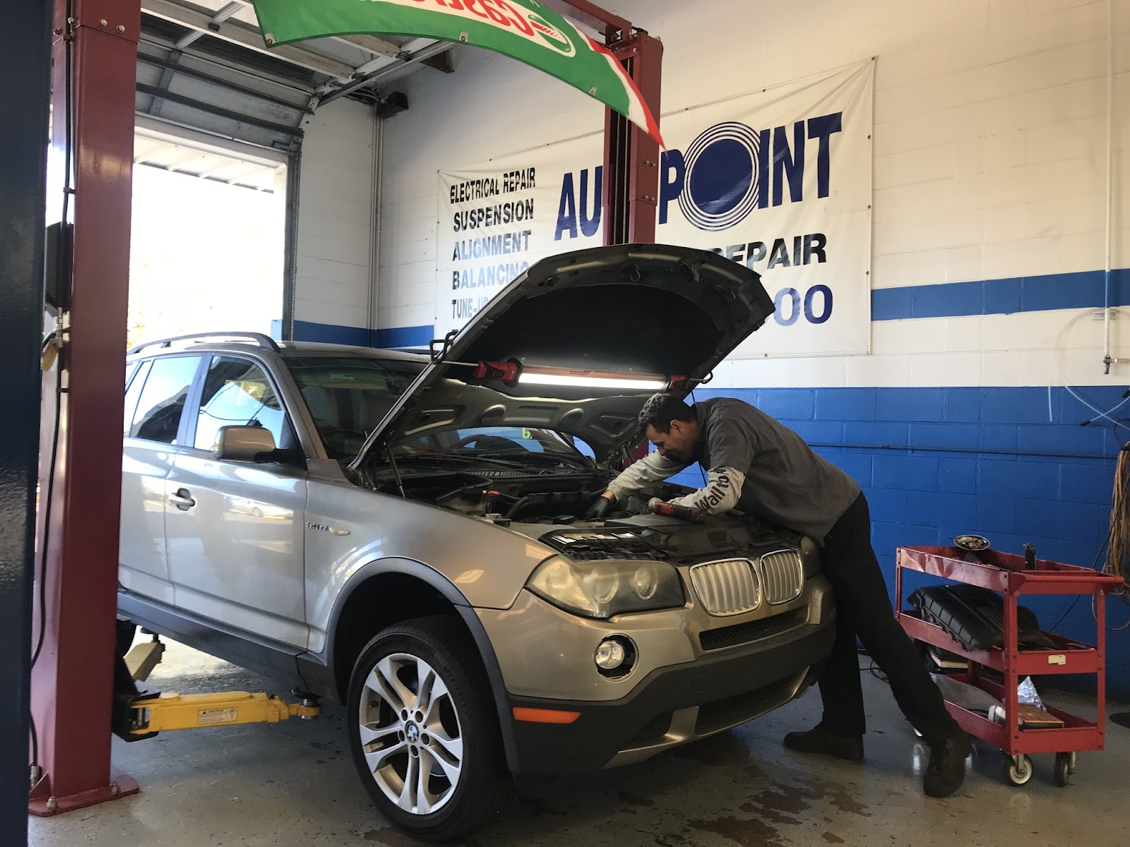 Auto Point Car Care technician repairing a BMW engine in Apopka shop